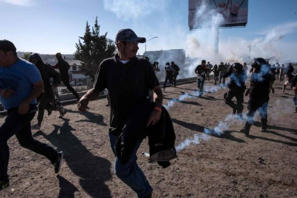 Fotos del momento en el que migrantes de la caravana saltaron valla fronteriza de Estados Unidos, pero fueron detenidos con gases lacrimógenos