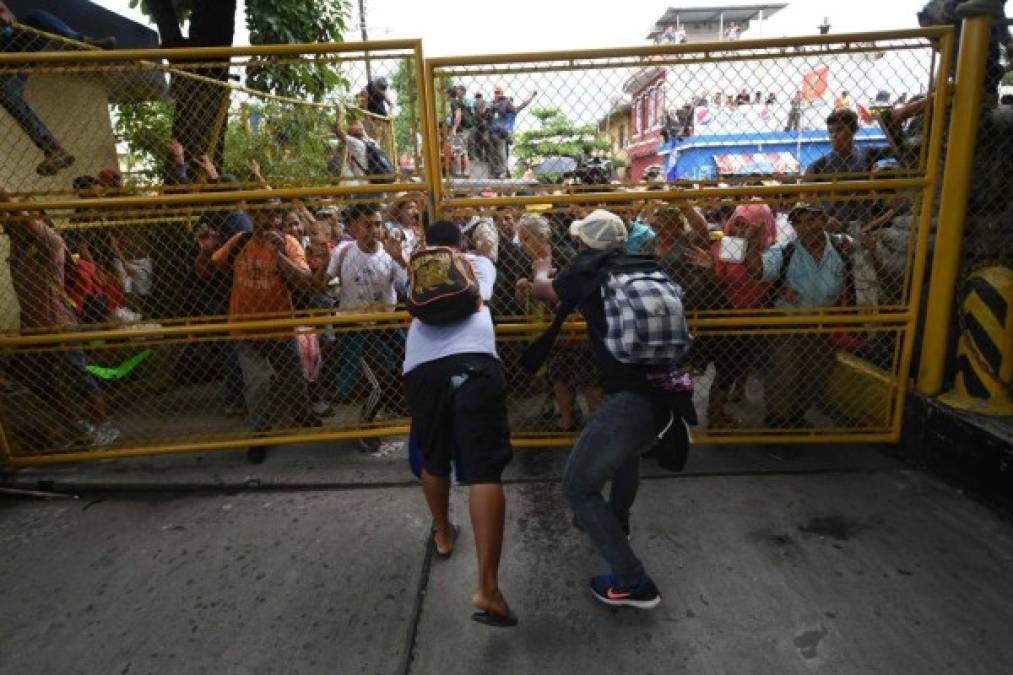 FOTOS: Así fue el momento en el que la caravana migrante de hondureños rompió los portones e ingresó a México