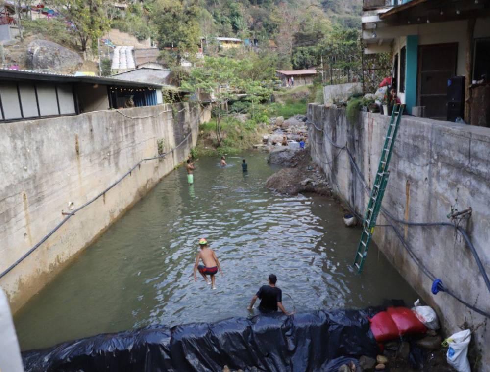 Los pobladores de San Juancito han formado una poza en el río que cruza en el centro de la aldea, grandes y pequeños se refrescan en esta agua que baja de la montaña.