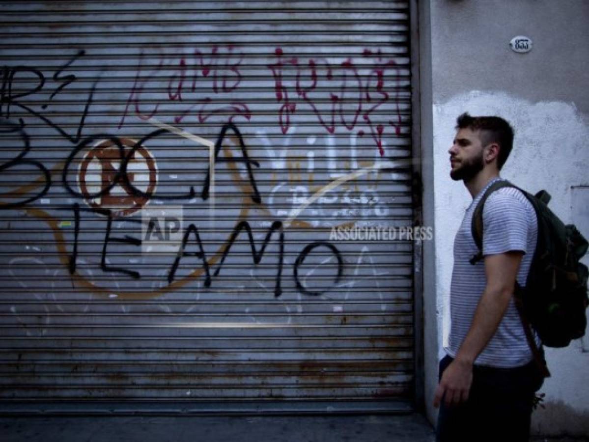 Un individuo camina frente a un graffiti con la frase Boca te amo en Buenos Aires, Argentina previo a la final de la Copa Libertadores. Foto:AP