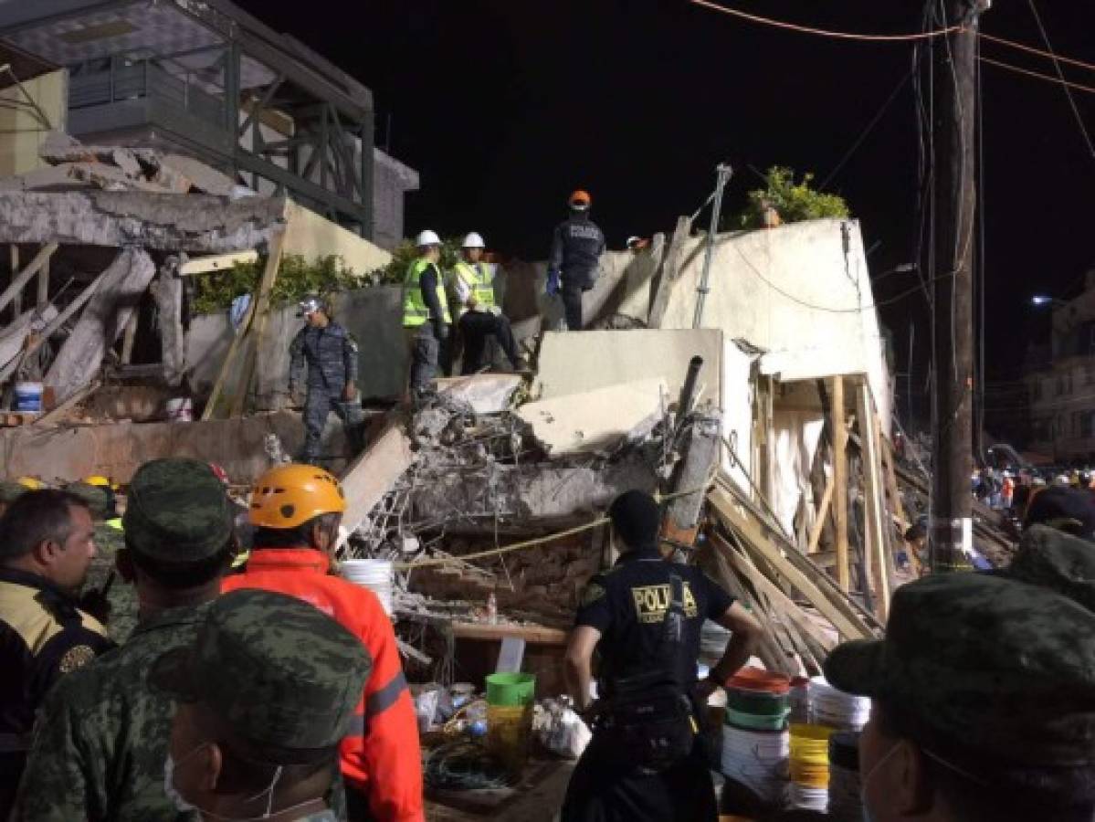 Rescue teams work at the Rébsamen school in Mexico City early morning on September 20, 2017.The number of people killed in a devastating earthquake that struck Mexico City and nearby regions has risen to 138, the government said. / AFP PHOTO / JOSE GARCIA