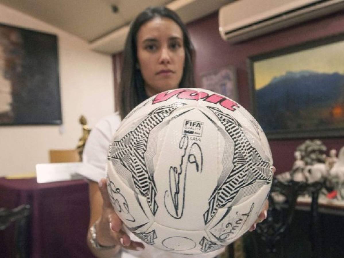 Deborah Gignac, esposa de Andre Pierre Gignac, muestra un balón autografiado por estrellas del fútbol (Foto: Agencia AFP)