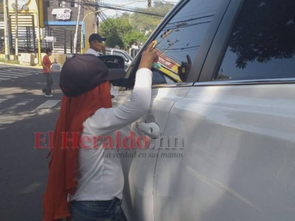 Ernel se asoma a través de los vidrios de los carros para tratar de convencer que le regalen algo de dinero. Foto: Alex Pérez/ EL HERALDO.