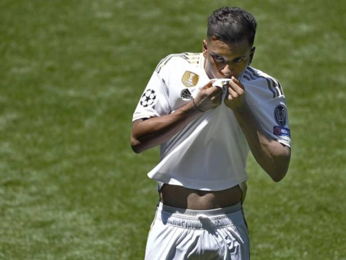 Brazilian forward Rodrygo Silva de Goes kisses his new jersey during his official presentation as new player of the Real Madrid CF at the Santiago Bernabeu stadium in Madrid on June 18, 2019. (Photo by OSCAR DEL POZO / AFP)