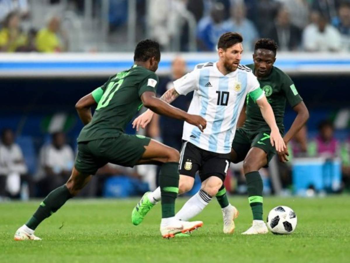 El delantero argentino Lionel Messi es marcado por el centrocampista nigeriano John Obi Mikel y el delantero nigeriano Ahmed Mus. Foto AFP