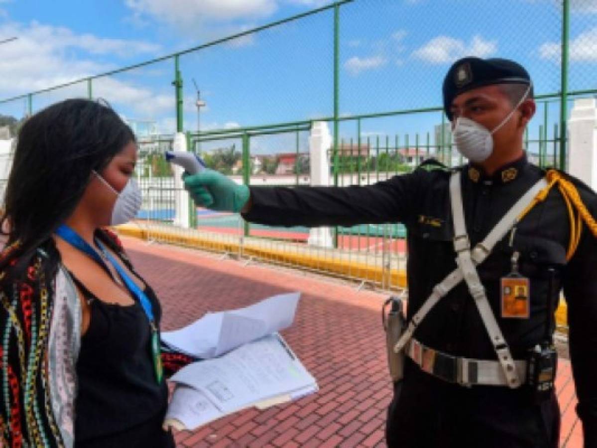 Un militar toma la temperatura de una ciudadana en Panamá, donde muchas actividades aún continúan prohibidas.