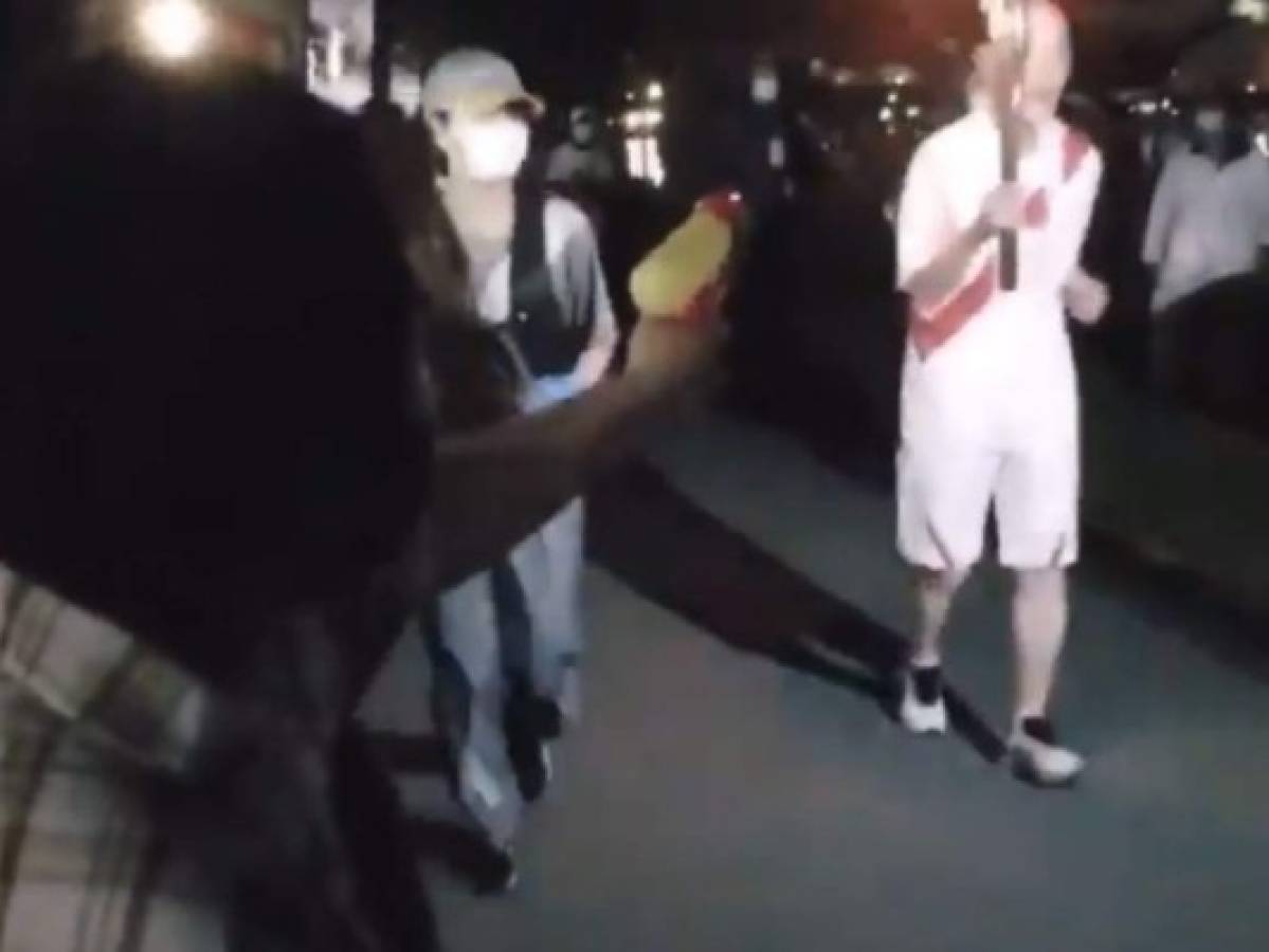 VIDEO: Mujer intenta apagar la antorcha olímpica con una pistola de agua