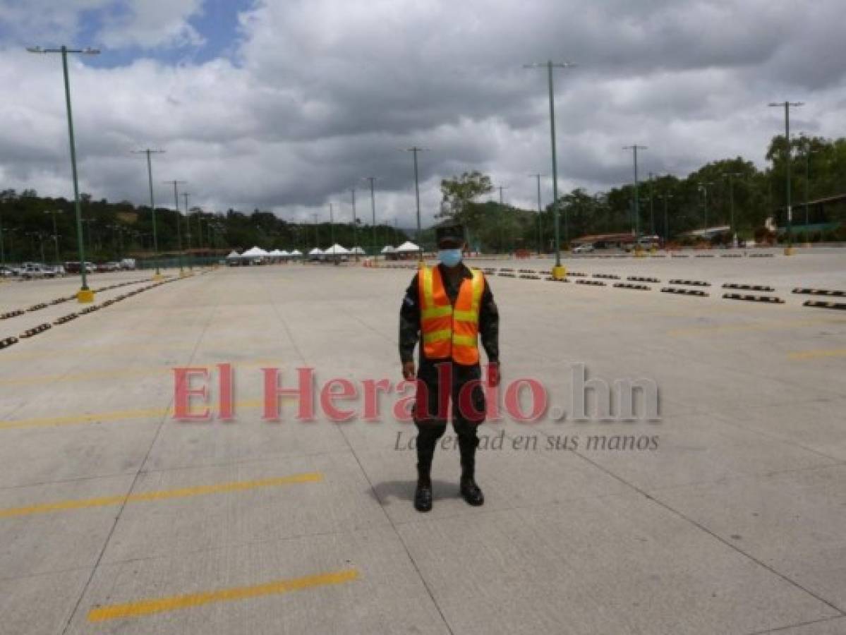 Un militar que presta asistencia para organizar los vehículos que ingresan a un centro de vacunación camina por el estacionamiento vacío. Foto: Johny Magallanes/ EL HERALDO