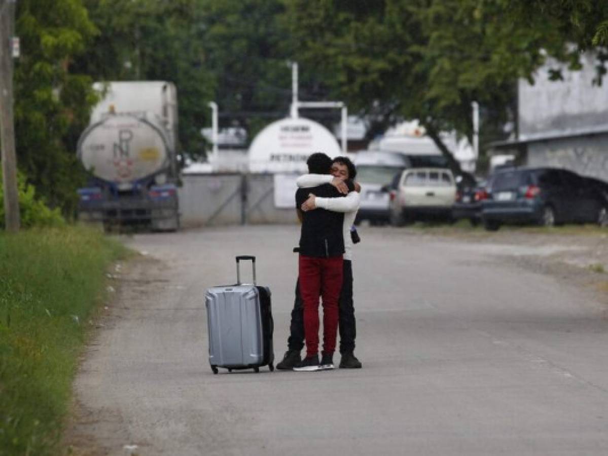 Un hombre que fue deportado de los Estados Unidos, en primer plano, es recibido por un pariente afuera del Aeropuerto Internacional Ramón Villeda en La Lima. Foto: AP.