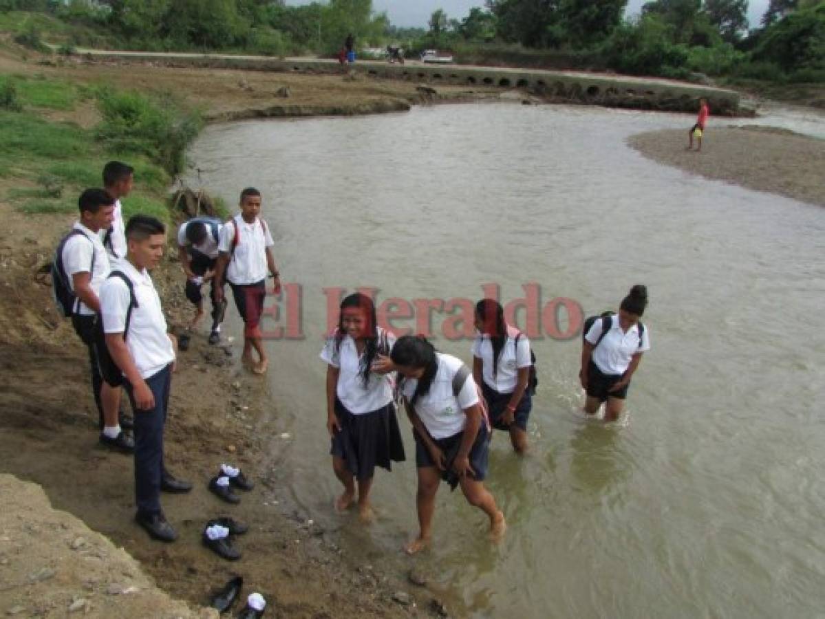 Alumnos del Instituto Unión de Oriente de Jutiapa cruzan un río para asistir a clases