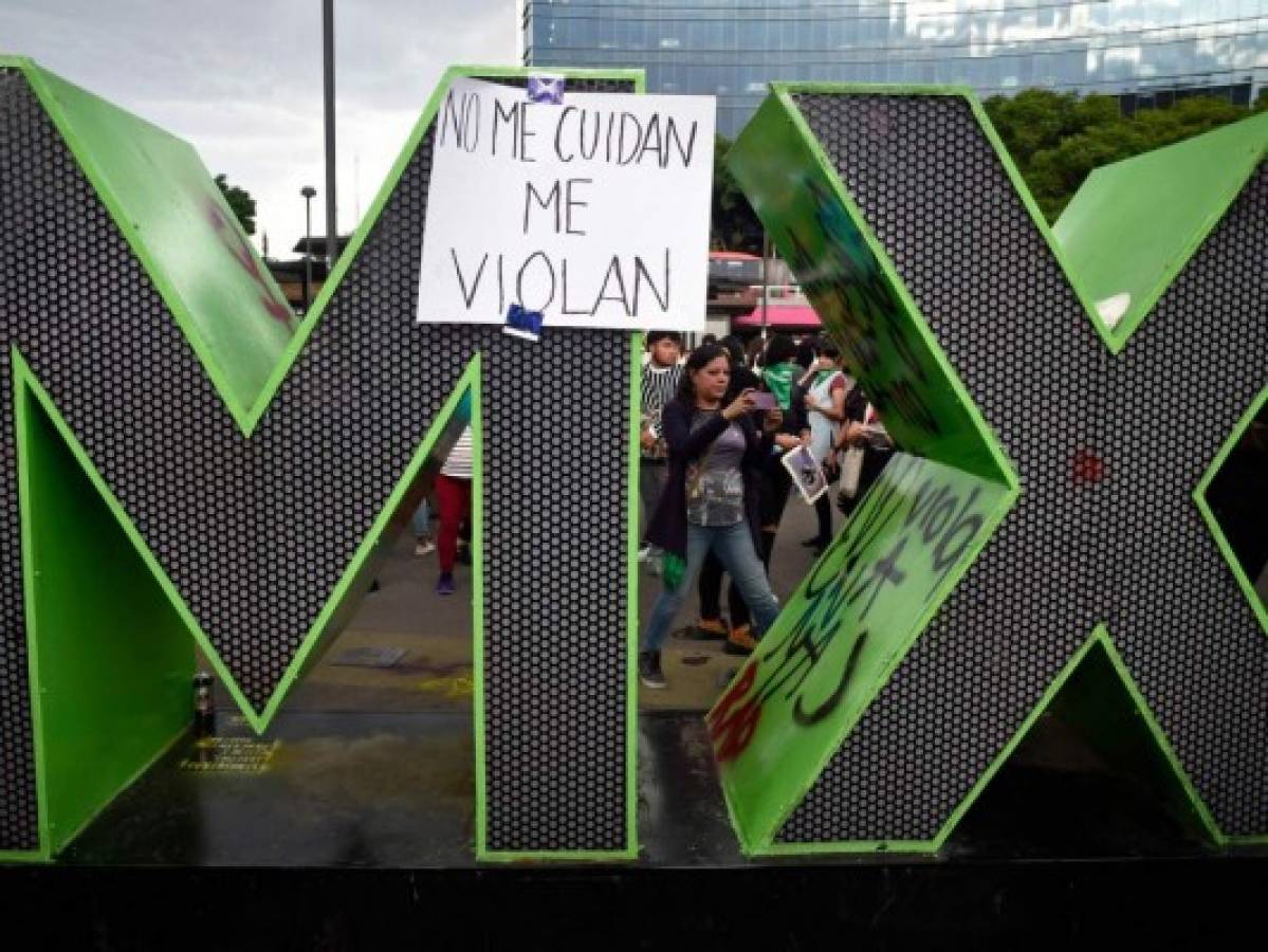 People demonstrate under the slogan '#NoMeCuidanMeViolan' (sign) ('#TheyDon'tProtectMe,TheyRapeMe') to demand justice for two teenage girls who say police officers raped them and protest against the lack of punishment and security, in front of the Ministry of Public Security in Mexico City on August 16, 2019. - The protests were sparked by two recent cases: that of a 17-year-old girl who says four policemen raped her in their patrol car as she left a party on the capital's north side, and that of a 16-year-old girl who says a policeman raped her at the national photography archive museum, in the city centre. No officers have been detained or punished so far in the first case. A policeman was arrested Thursday in the second. (Photo by Alfredo ESTRELLA / AFP)