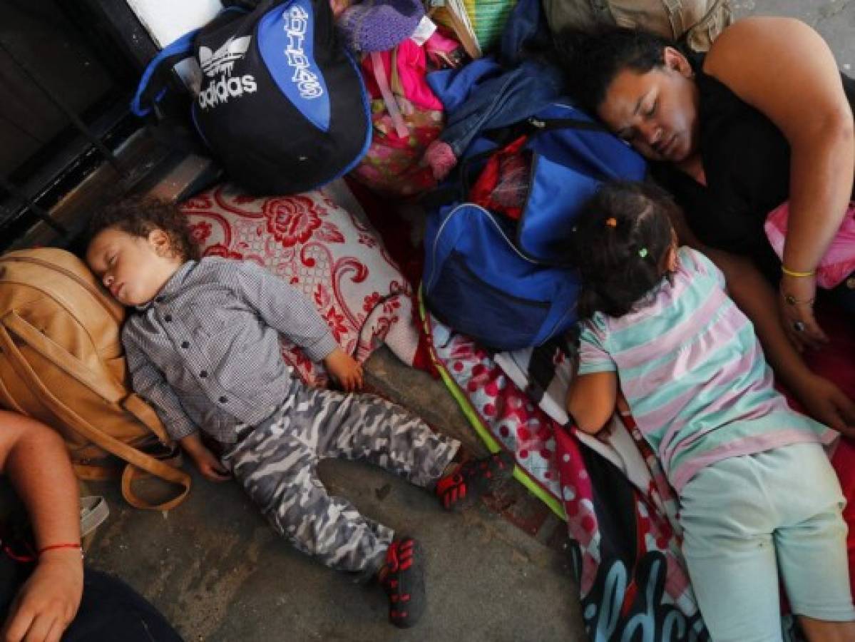 Migrantes hondureÃ±os descansan mientras esperan para cruzar la frontera a MÃ©xico, en Tecun Uman, Guatemala, el 17 de enero de 2020. (AP Foto/Marco Ugarte)