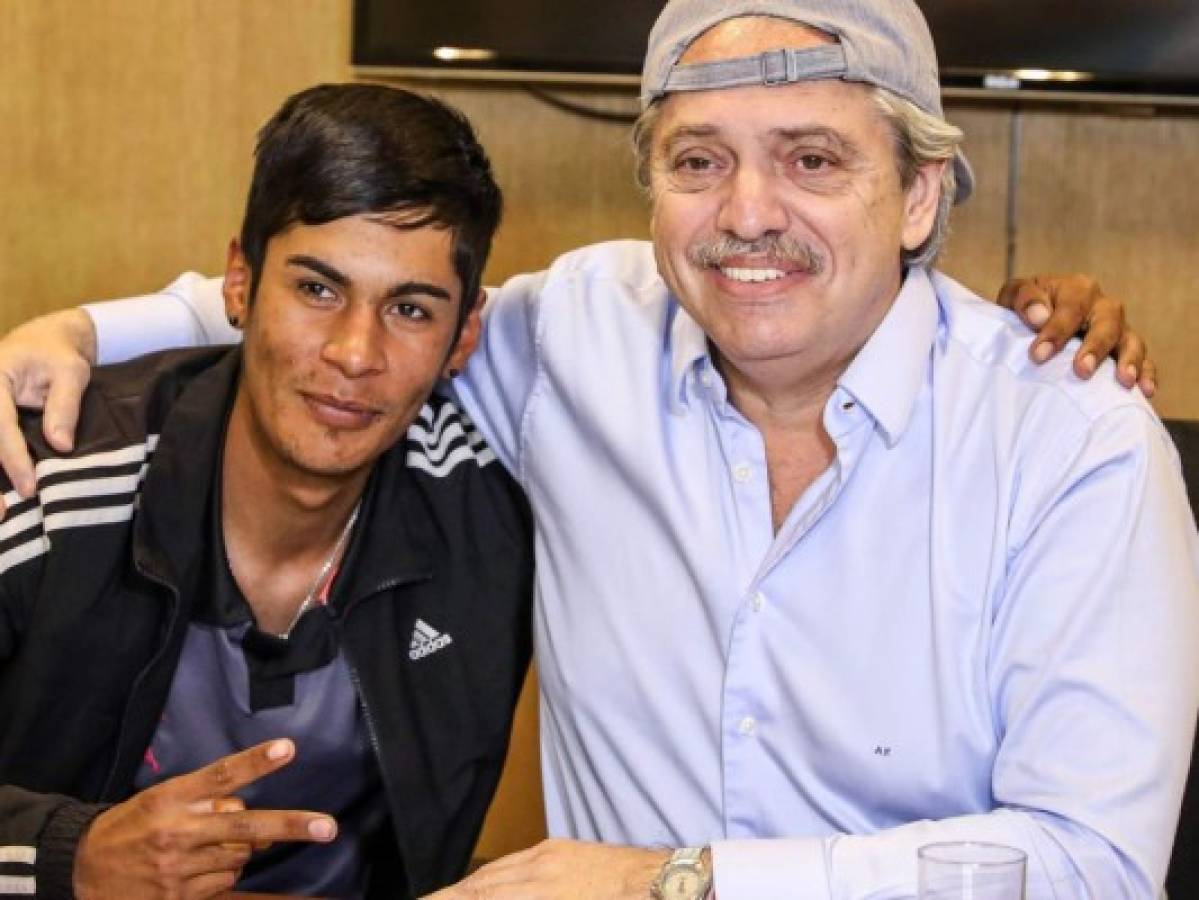 Handout photo released by the press office of president-elect Alberto Fernandez (R) showing himself posing with Brian Gallo in Buenos Aires on October 30, 2019. - Argentina's president-elect Alberto Fernandez came out in defense of Brian Gallo, a young man who's picture serving as a table president in the elections went viral with many discriminating against him because of his clothes. (Photo by HO / Alberto Fernandez press office / AFP)