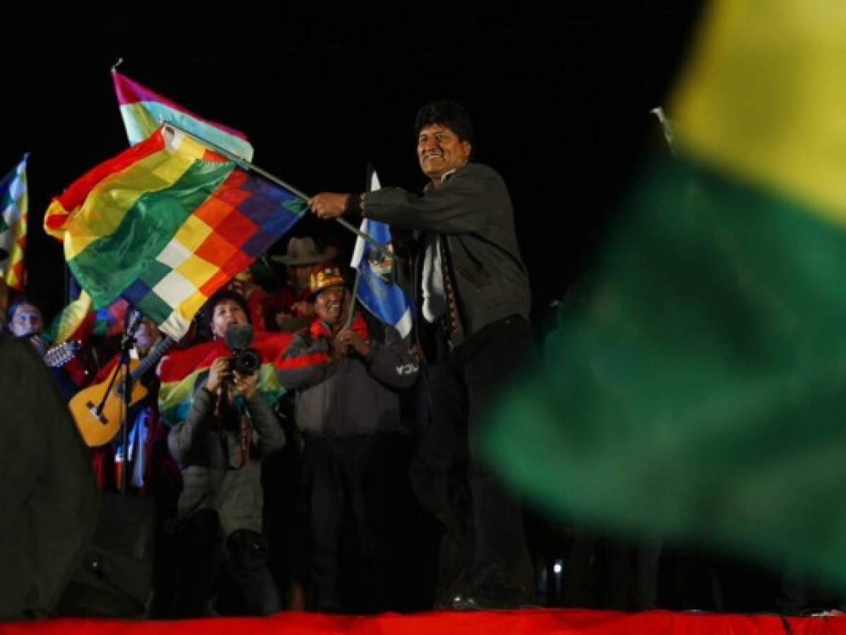El presidente de boliviano Evo Morales ondea banderas ante sus partidarios mientras celebra su reelección junto con el vicepresidente Álvaro García Linera en El Alto, Bolivia. Foto: AP.