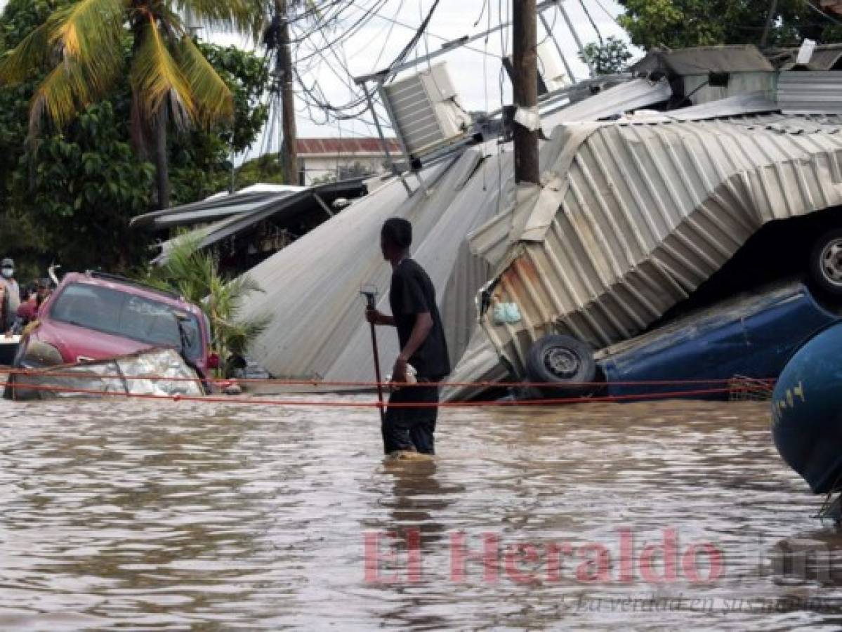 ARCHIVO - En esta foto de archivo del 6 de noviembre de 2020, un residente que camina por una calle inundada observa los daÃ±os causados ââpor el huracÃ¡n Eta en Planeta, Honduras. Las familias hondureÃ±as y guatemaltecas inundadas que quedaron varadas en los tejados de los barrios mÃ¡s marginados tras el paso de los huracanes Eta e Iota presagian una nueva ola de migraciÃ³n, segÃºn observadores de la regiÃ³n. (AP Foto/Delmer MartÃ­nez, Archivo)