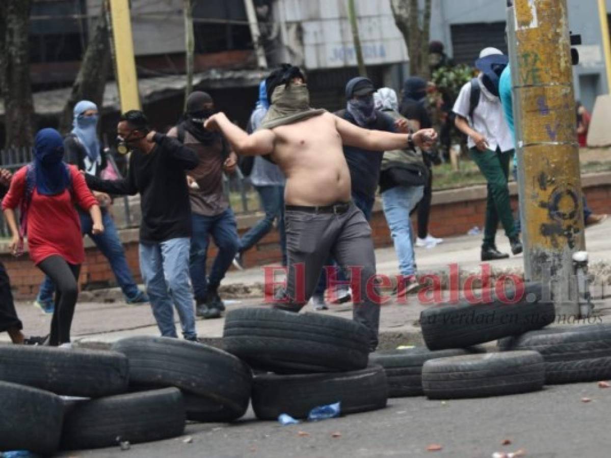 En esta imagen un encapuchado lanza piedras a los uniformados. Foto Alex Pérez| EL HERALDO