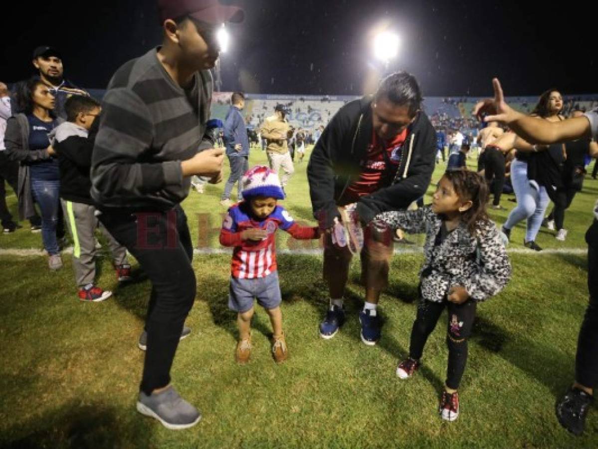 Padre e hijo sufren el golpe del gas lacrimógeno que se esparció por todo el Estadio Nacional. (Fotos: Johny Magallanes / EL HERALDO)