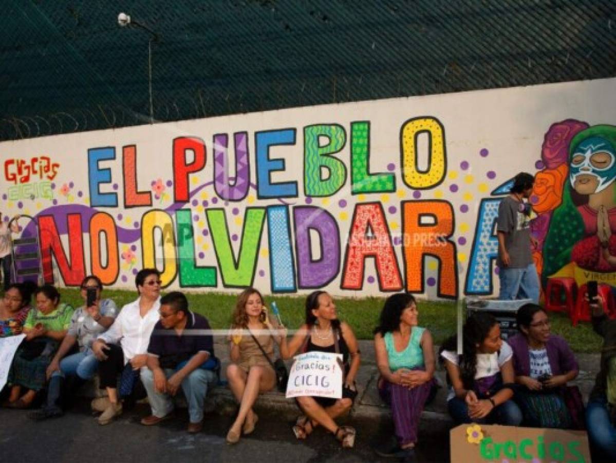 Artistas y activistas posan para una foto junto a un mural en la sede de la Comisión Internacional contra la Impunidad de las Naciones Unidas, CICIG, en la ciudad de Guatemala, el sábado 31 de agosto de 2019. La misión de la ONU está cerrando sus operaciones después de 12 años. Foto: AP.