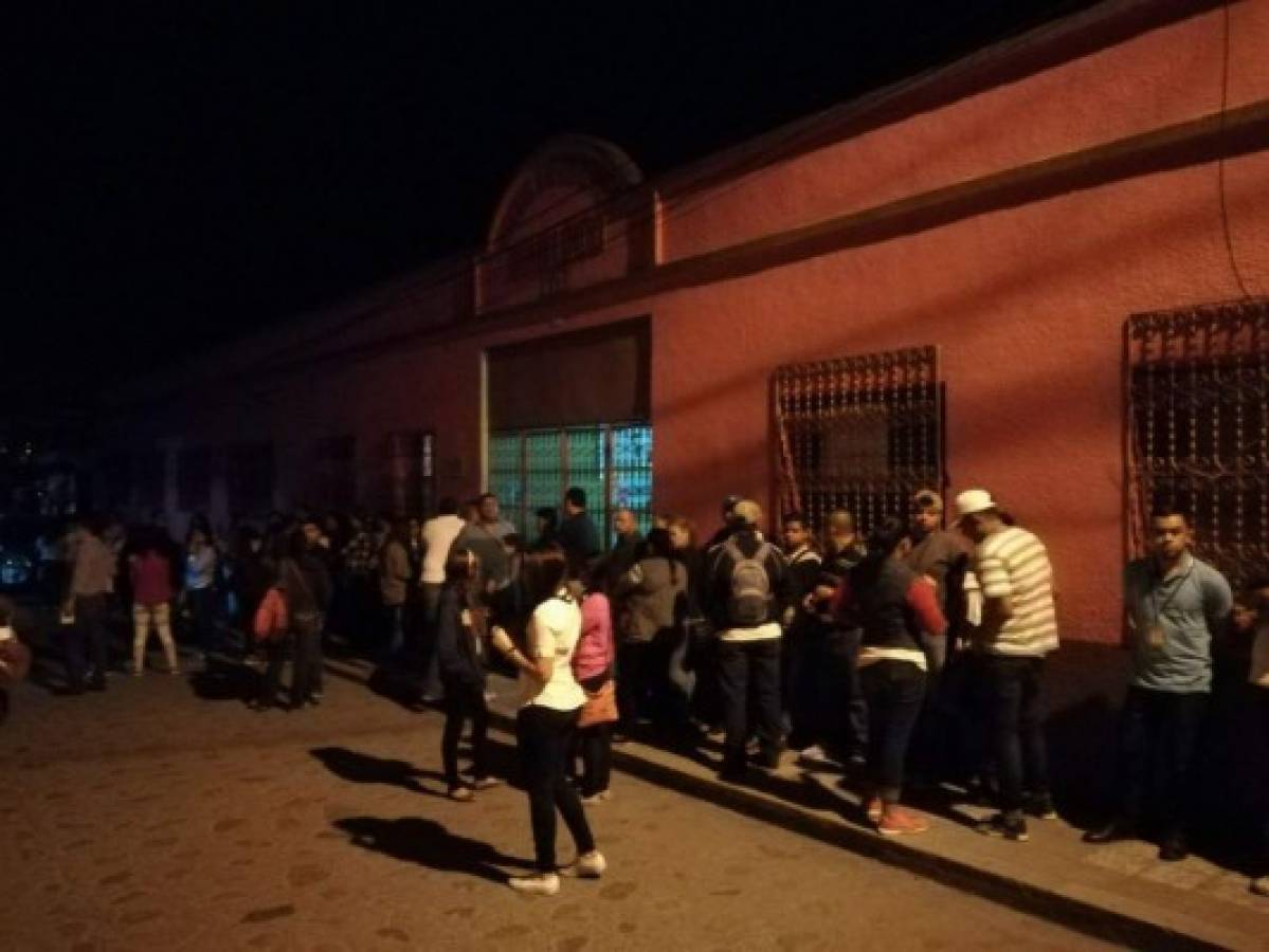 Miembros electorales esperan la apertura de la escuela en la que votará Juan Orlando Hernández