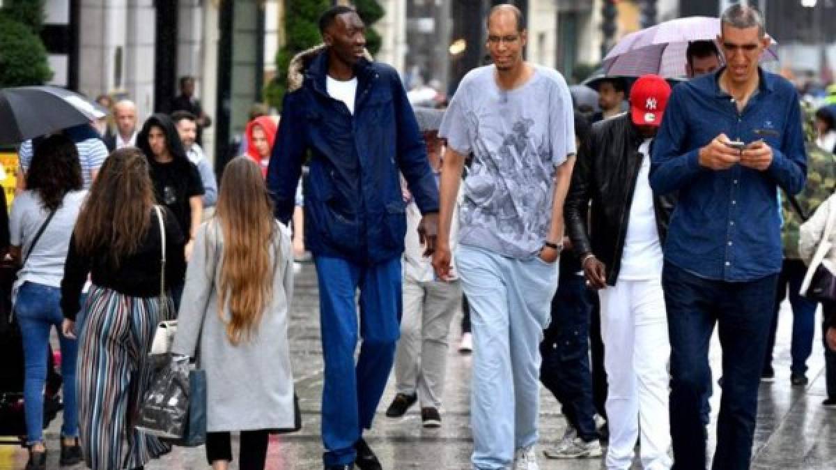 Así lucen los hombres más altos del mundo, caminando por París. (AFP)