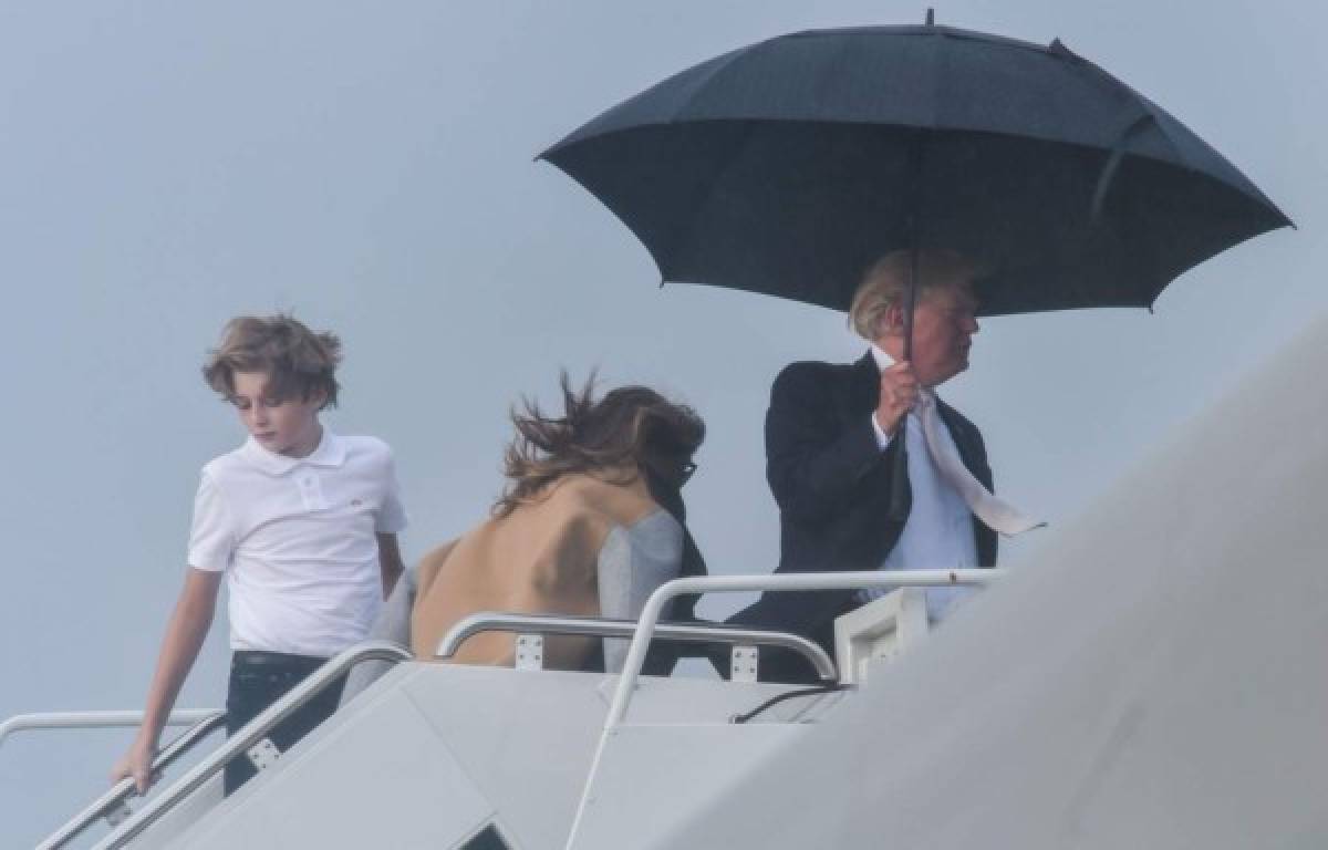 La primera dama Melania Trump que venía detrás de su hijo y esposo, no tienen paraguas.