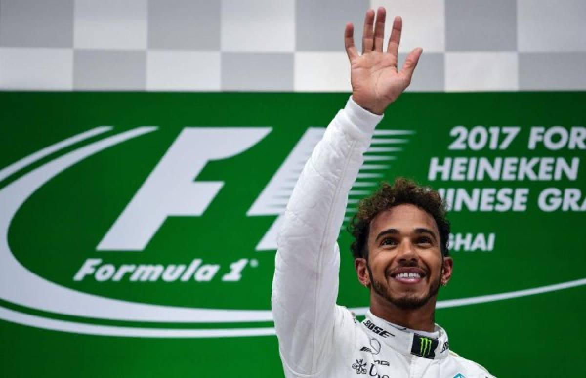 TOPSHOT - Mercedes' British driver Lewis Hamilton celebrates on the podium after winning the Formula One Chinese Grand Prix in Shanghai on April 9, 2017. / AFP PHOTO / Johannes EISELE