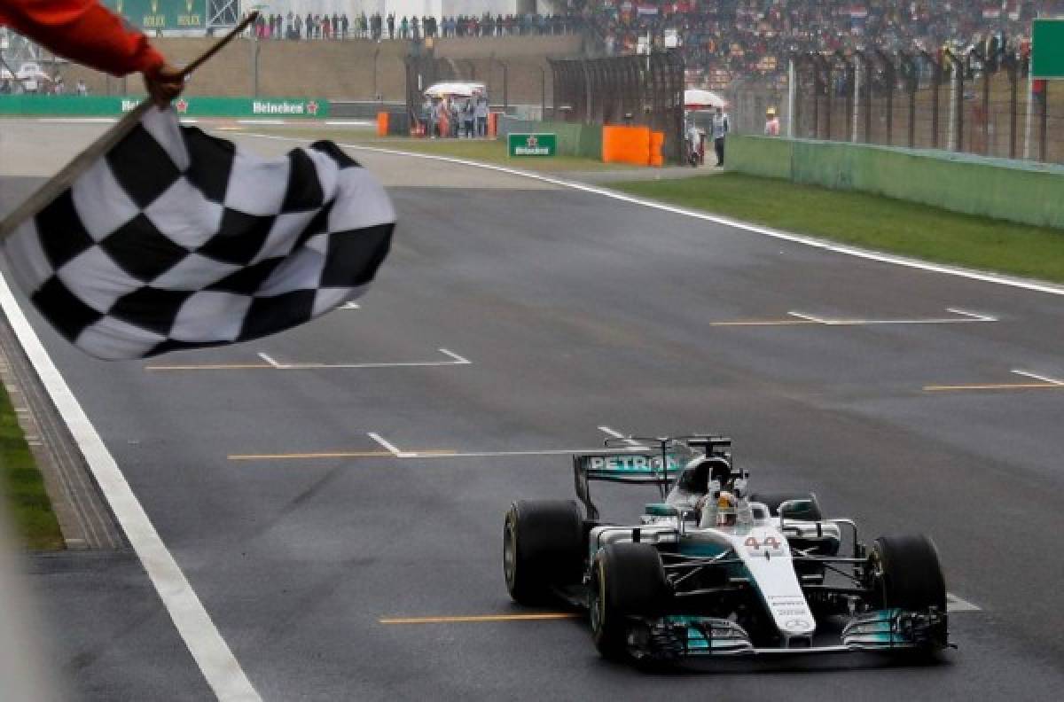 Mercedes' British driver Lewis Hamilton drives his car past the chequered flag to win the Formula One Chinese Grand Prix in Shanghai on April 9, 2017. / AFP PHOTO / POOL / Andy WONG