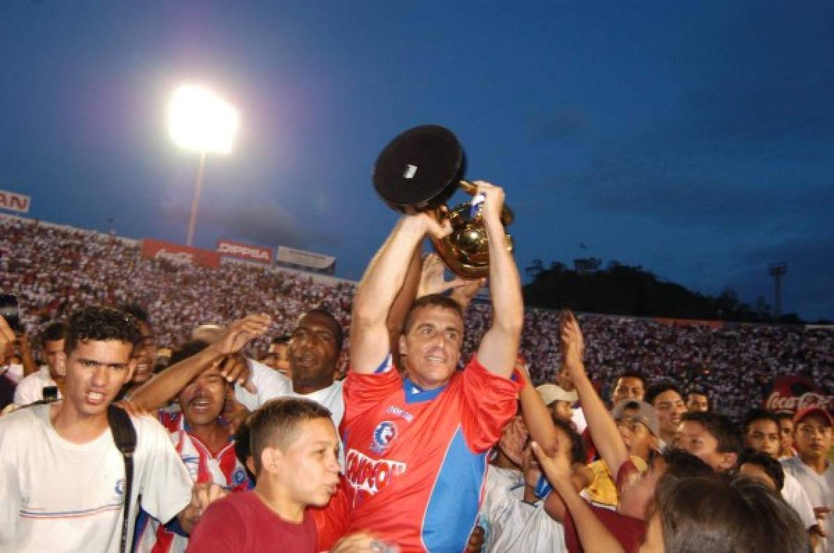 Tosello levantando una de las copas que logró con Olimpia.