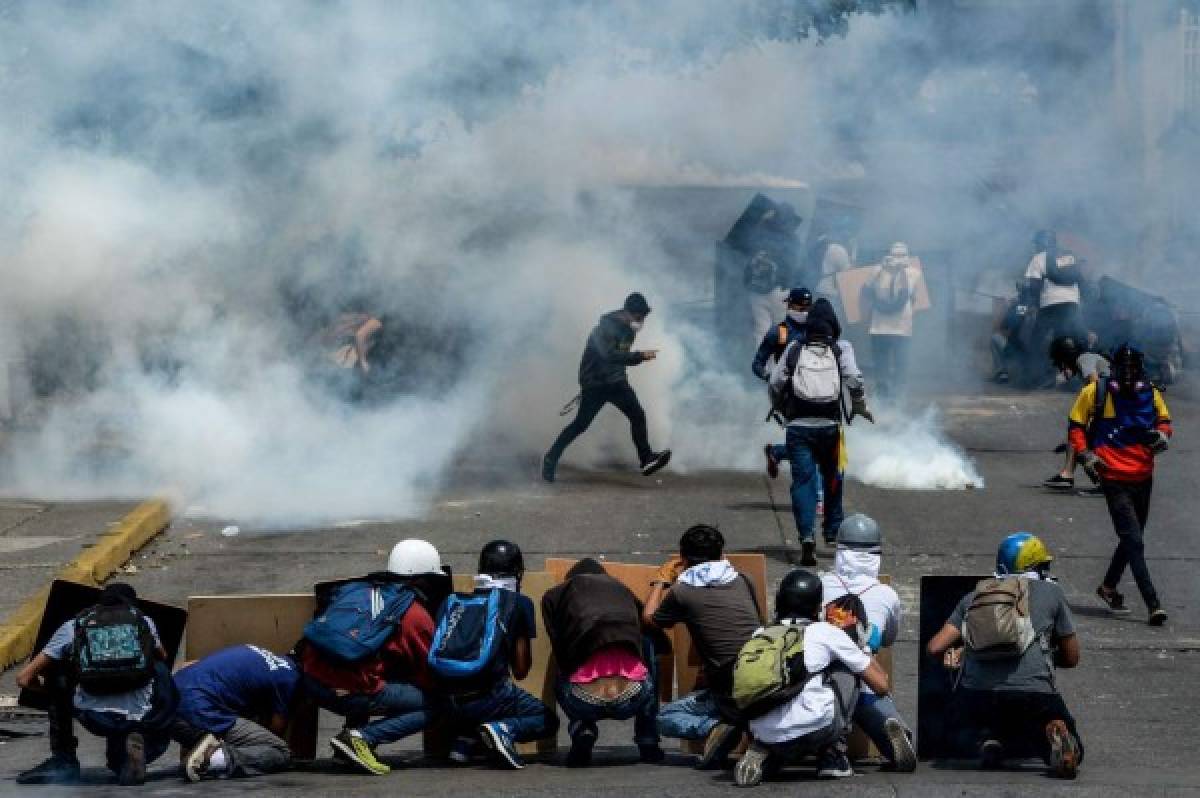 Opposition activists demonstrating against the government of Venezuelan President Nicolas Maduro clash with riot policeice in Caracas on June 26, 2017. A political and economic crisis in the oil-producing country has spawned often violent demonstrations by protesters demanding Maduro's resignation and new elections. The unrest has left 75 people dead since April 1. / AFP PHOTO / FEDERICO PARRA