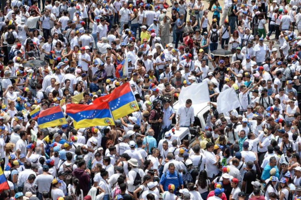 Venezuelan opposition activists march in a quiet show of condemnation of the government of President NIcolas Maduro, in Caracas, on April 22, 2017.Venezuelans gathered Saturday for 'silent marches' against President Nicolas Maduro, a test of his government's tolerance for peaceful protests after three weeks of violent unrest that has left 20 people dead. / AFP PHOTO / FEDERICO PARRA