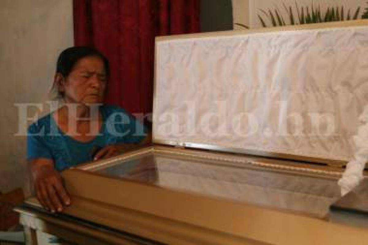 Doña Leonor Villalta se aferra al cajón donde descansa su esposo Rogelio Munguía (Foto: Emilio Flores/ El Heraldo Honduras/ Noticias de Honduras)
