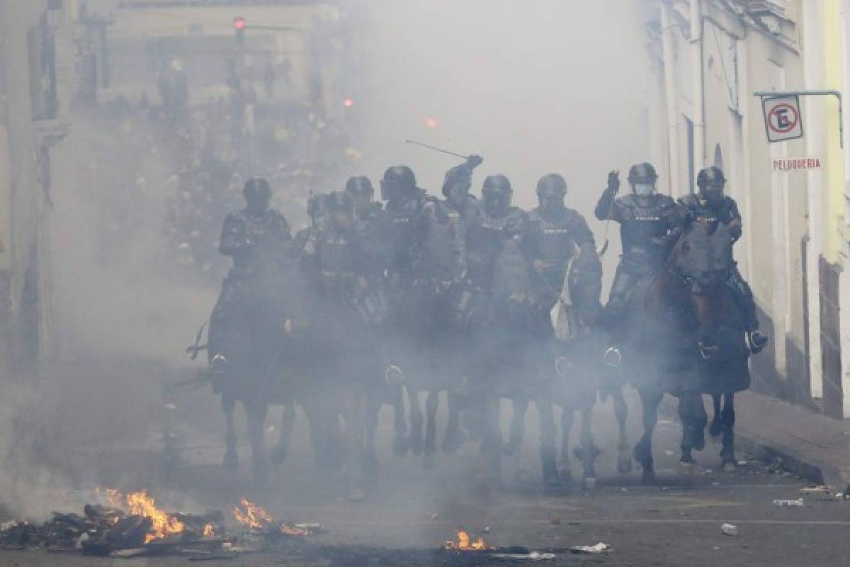 La policía montada cruza una barricada mientras persigue a manifestantes durante una protesta contra el presidente Lenín Moreno. Foto: AP.