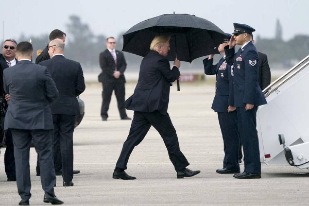 Trump se cubre de la lluvia mientras Melania y su hijo Barron se mojan (FOTOS)