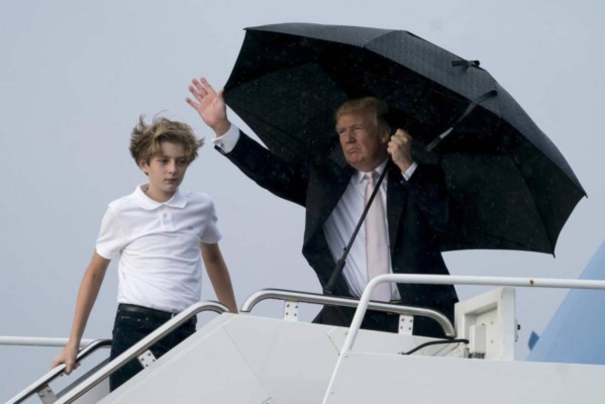 Trump se cubre de la lluvia mientras Melania y su hijo Barron se mojan (FOTOS)