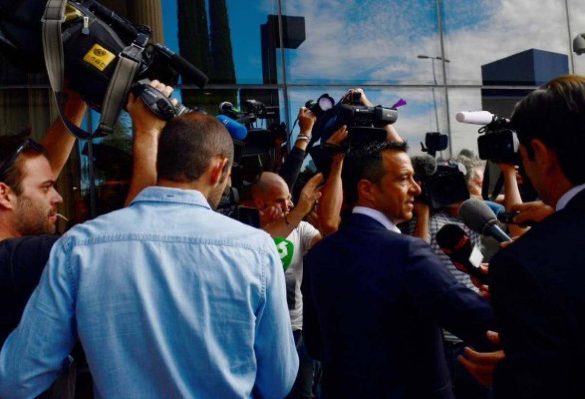 Footballing super-agent Jorge Mendes (R), surrounded by journalists, arrives at the Court in Pozuelo de Alarcon on June 27, 2017 to be questioned by Spanish judge as part of a probe into Colombian striker Radamel Falcao's alleged tax evasion. / AFP PHOTO / PIERRE-PHILIPPE MARCOU