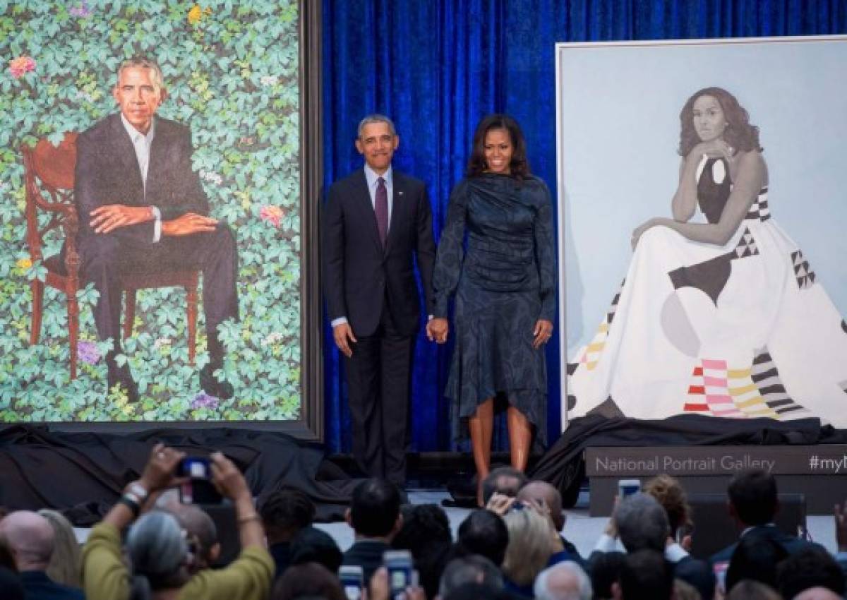 Los Obama parados junto a los retratos que estarán en el National Portrait Gallery. Foto: AFP