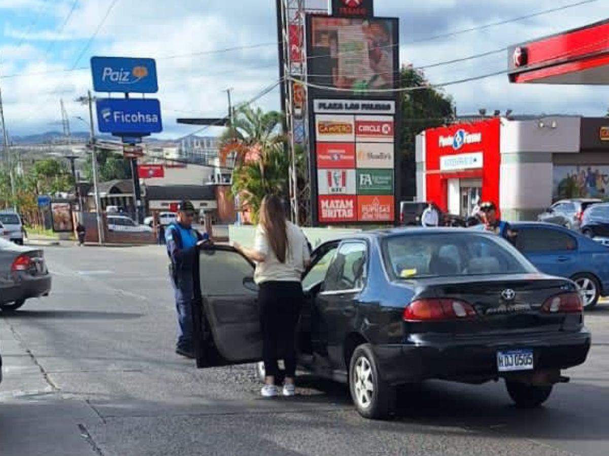 En esta imagen se ve a Andrea Josefina Sánchez fuera de su vehículo mientras que el agente municipal sostiene un celular en sus manos.