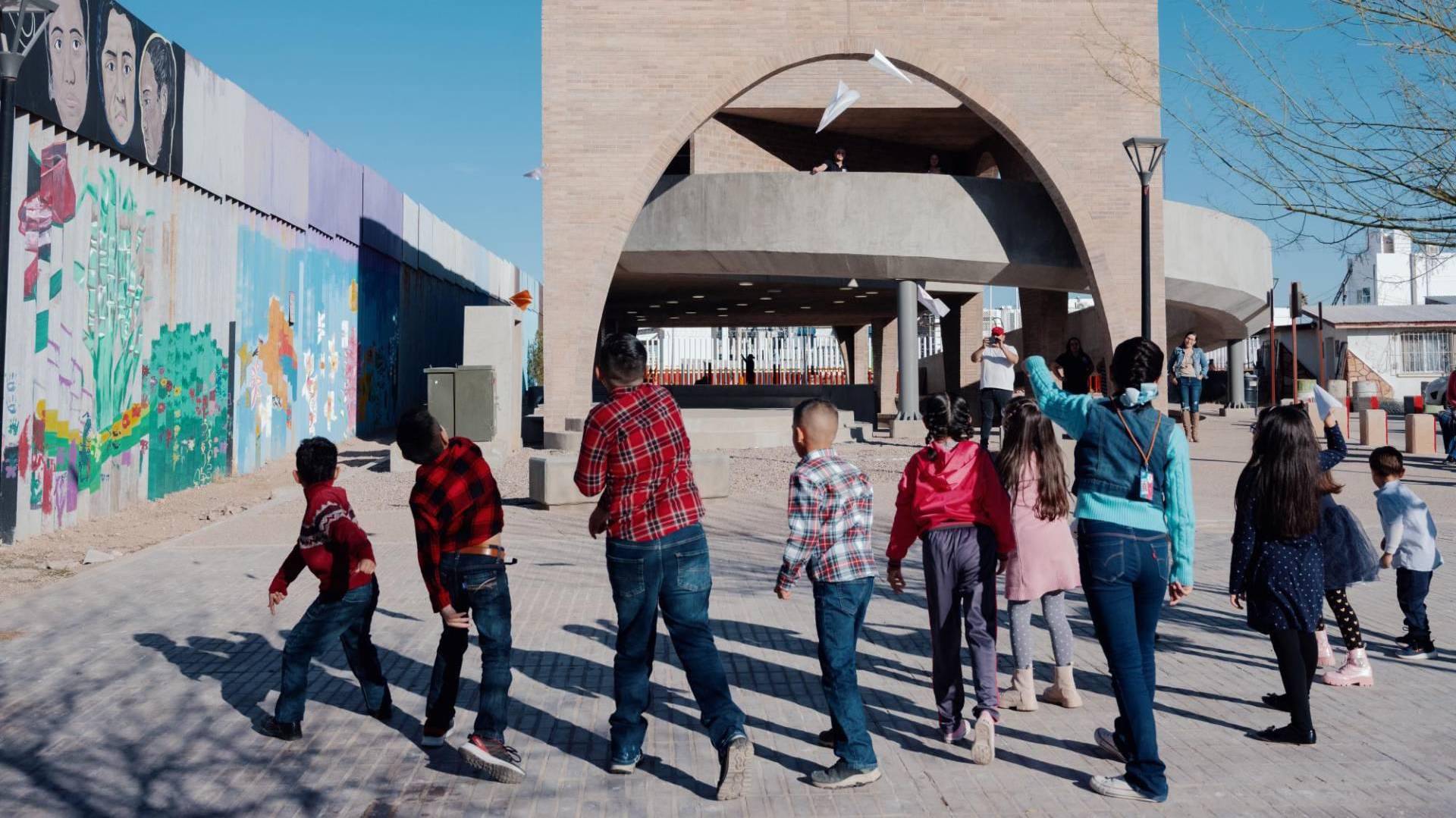 $!Niños juegan en el nuevo parque público de la biblioteca de Agua Prieta, junto al muro fronterizo lleno de murales.
