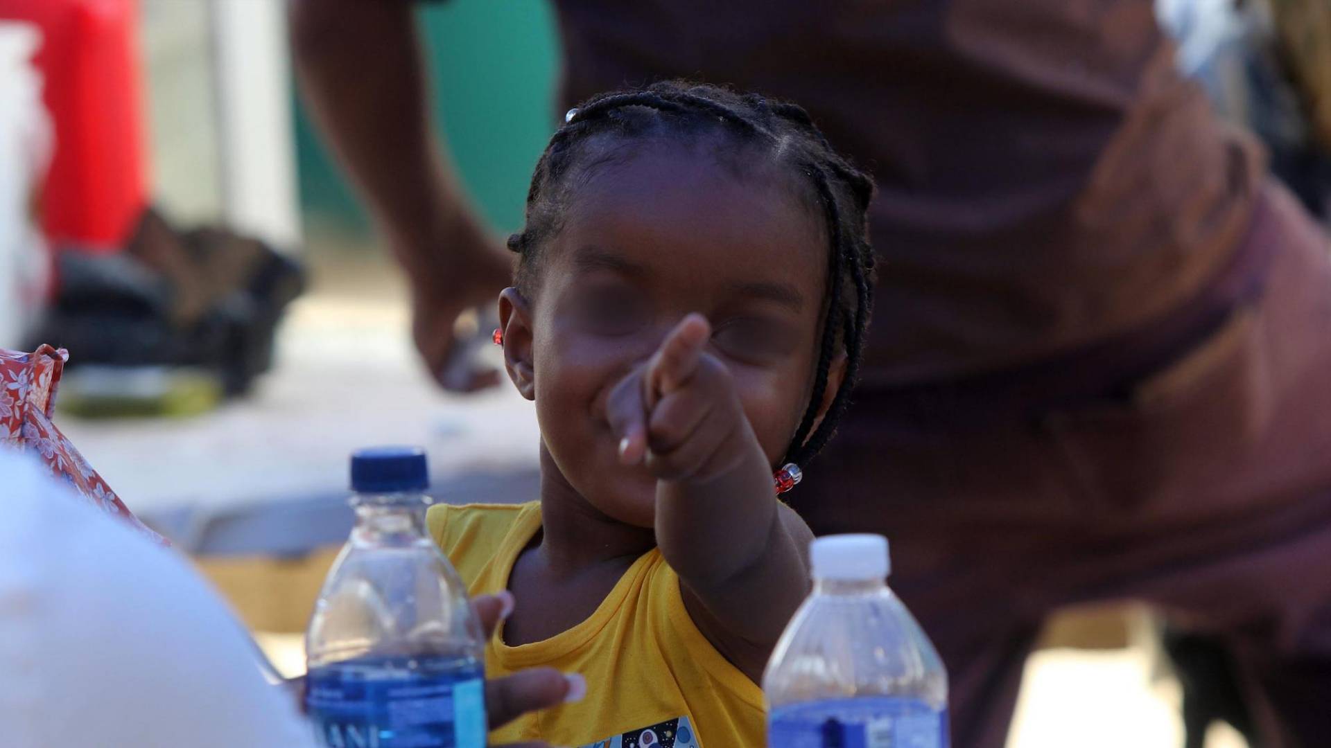 $!Esta niña haitiana se alertó de la fotografía que le estaban tomando y no dudó en señalar entre risas al responsable.