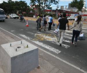 Algunos peatones son apoyados por agentes de orden vial de la comuna capitalina. En el bulevar Suyapa se instalará un semáforo con sistema inteligente para los transeúntes. Foto: Efraín Salgado/EL HERALDO.