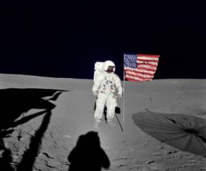 Esta imagen de la NASA sin fecha obtenida el 5 de febrero de 2016 muestra al astronauta Edgar D. Mitchell, piloto del módulo lunar del Apolo 14, de pie junto a la bandera estadounidense desplegada en la superficie lunar durante los primeros momentos de la primera caminata espacial de la misión. Foto AFP.