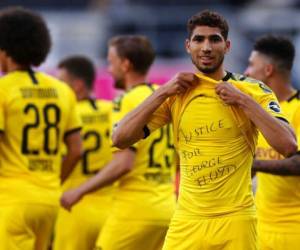 Chraf Hakimi Mouh, del Borussia Dortmund celebra tras anotar el cuarto gol de su equipo con una camiseta con la leyenda 'Justicia para George Floyd' durante el duelo ante el SC Paderborn 07 en Paderborn, Alemania, el domingo 31 de mayo de 2020. Foto: AP