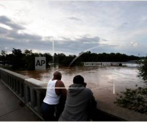 Gerald Generette, derecha, y Maurice Millen observan el río Cape Fear mientras sus niveles continúan aumentando a causa de Florence, en Fayetteville, Carolina del Norte, el lunes 17 de septiembre de 2018.