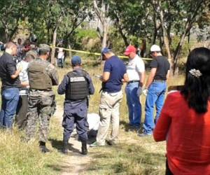 Agentes policiales y curiosos llegaron a la escena del crimen, en un campo deportivo.