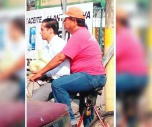Un padre hondureño utiliza una bicicleta para llevar diariamente a su hijo, quien se dirige a su trabajo.