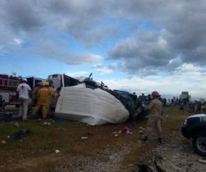 Bomberos y miembros de la Cruz Roja realiza laboreas tras la mortal colisión.