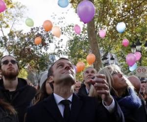Macron participó también en un acto frente a la alcaldía del distrito XI de París en la que se soltaron docenas de globos multicolores en honor a los muertos. (Foto: AFP/ El Heraldo Honduras/ Noticias Honduras hoy)