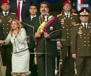 Esta imagen tomada de un vÍdeo de Venezolana de Televisión muestra el momento en que el presidente Nicolás Maduro, al centro, pronunciaba un discurso y su esposa, Cilia Flores, voltea hacia arriba cuando reacciona al sonido de una una explosión durante un acto en Caracas, Venezuela, el sábado 4 de agosto de 2018.