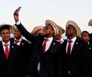Los miembros del equipo vestían trajes azul marino, camisa blanca y corbata roja. Muchos de ellos lucían también el sombrero pinta'o, típico de su país.