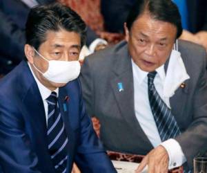 El primer ministro japonés Shinzo Abe, izquierda, y el ministro de Hacienda, Taro Aso, asisten a una sesión de la cámara alta en Tokio, miércoles 1 de abril de 2020.